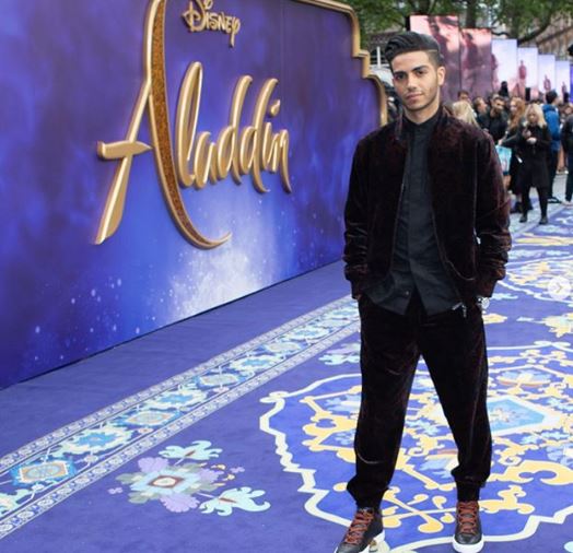 Mena Massoud on the red Carpet wearing baggy trousers