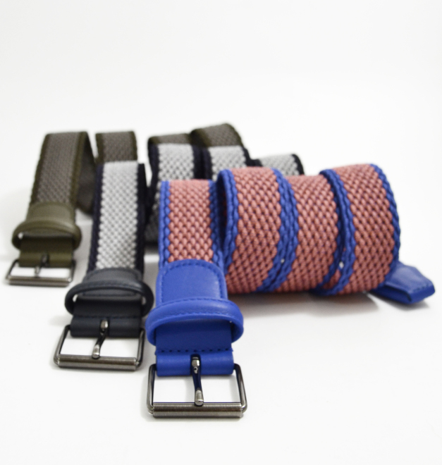 Three Anderson belts in brown black and blue. They are rolled neatly side by side on a white background. 